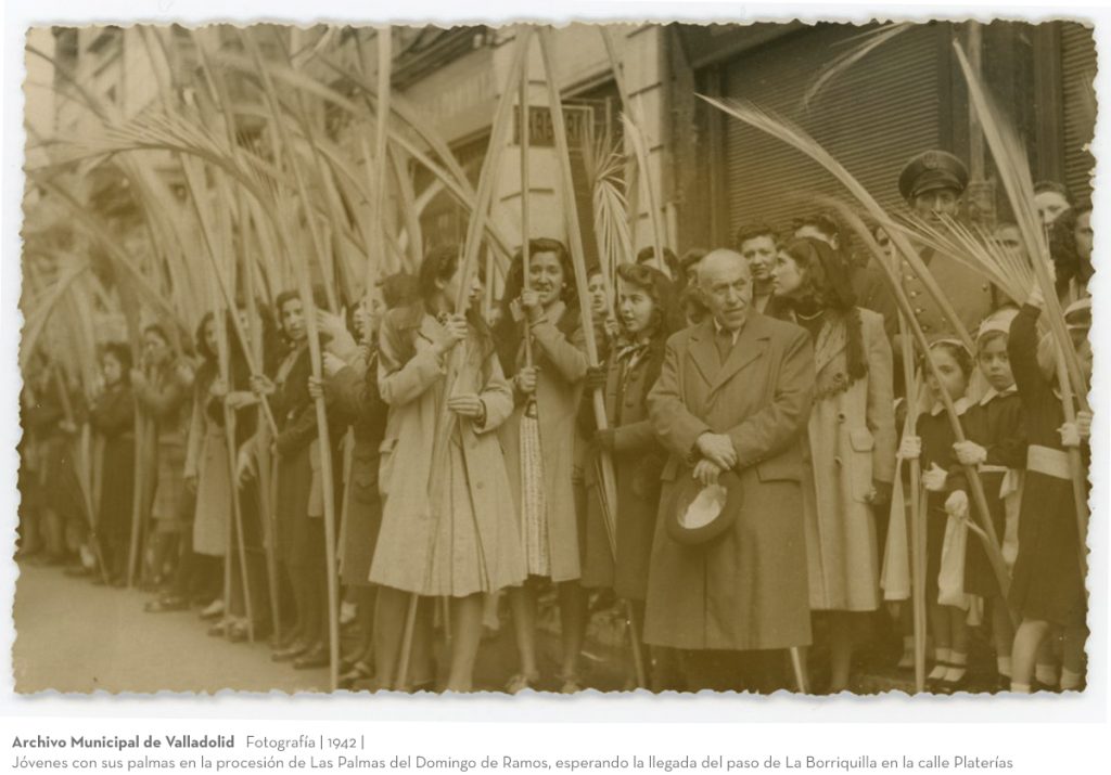 Fotografía. 1942. Jóvenes con sus palmas en la procesión de Las Palmas del Domingo de Ramos, esperando la llegada del paso de La Borriquilla en la calle Platerías