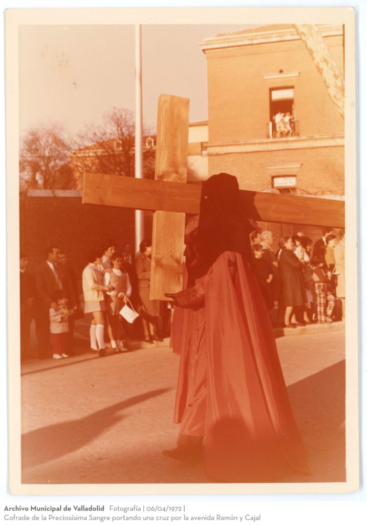Fotografía. 06/04/1972. Cofrade de la Preciosísima Sangre portando una cruz por la avenida Ramón y Cajal